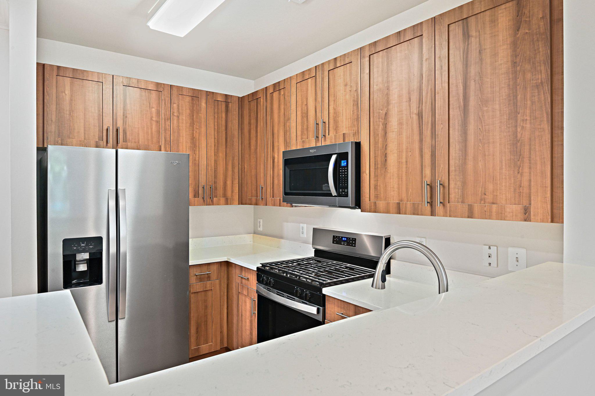 12001 Market Street, Unit 151 Reston, VA 20190 - Photo 5 of 25 a kitchen with stainless steel appliances granite countertop a refrigerator stove and sink