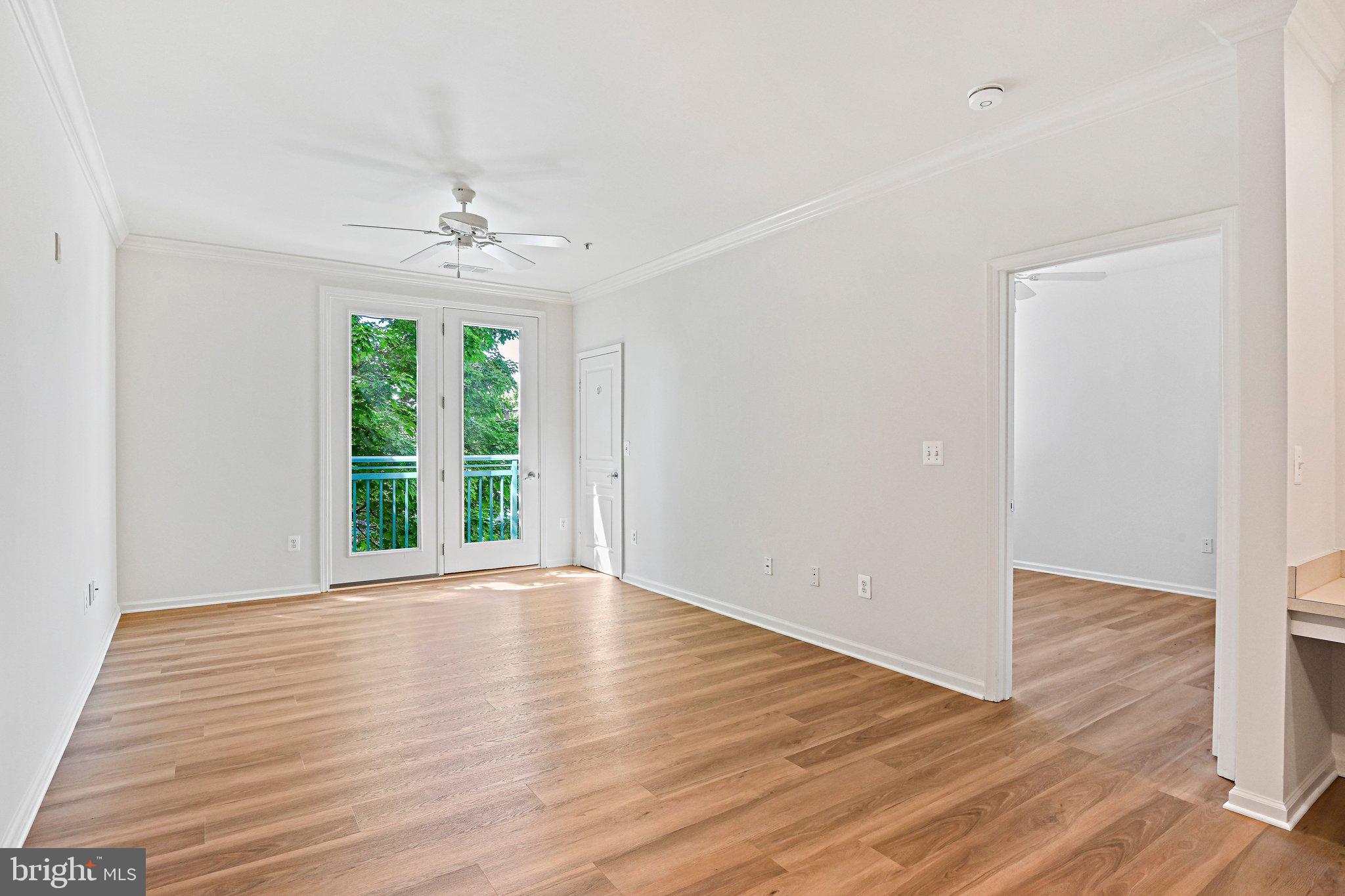 12001 Market Street, Unit 151 Reston, VA 20190 - Photo 7 of 25 a view of an empty room with wooden floor and a window