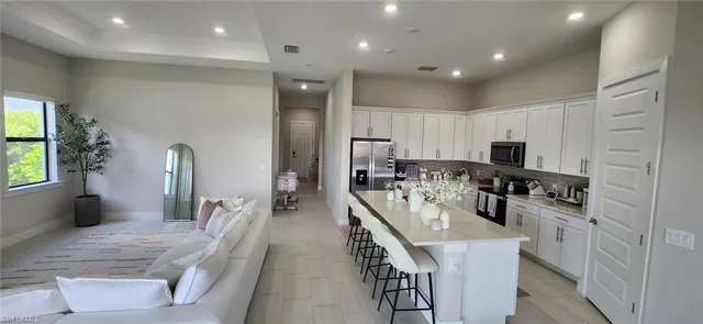a large kitchen with kitchen island a sink appliances and a counter top space