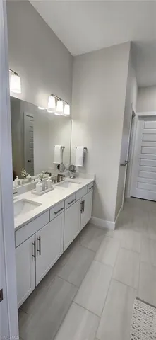 a spacious bathroom with a double vanity sink and mirror
