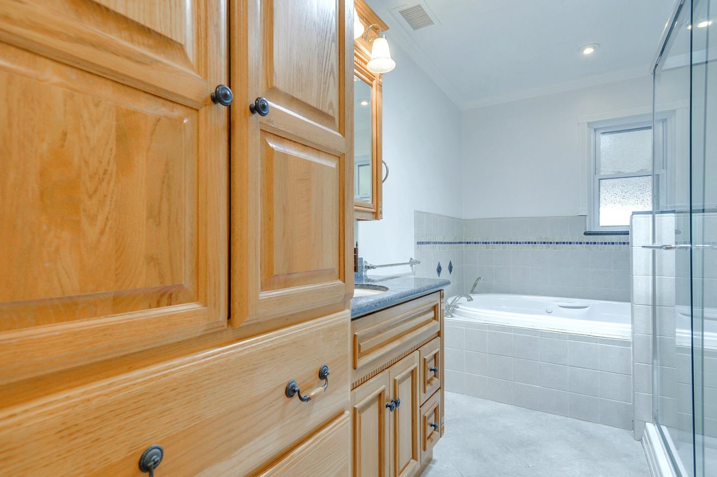 1228 Ruby Street Redwood City, CA 94061 - Photo 15 of 28 a bathroom with a bathtub and a shower