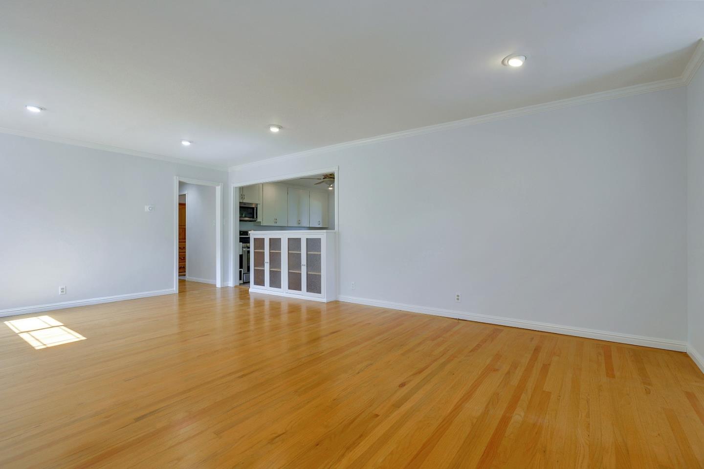 1228 Ruby Street Redwood City, CA 94061 - Photo 5 of 28 a view of an empty room with wooden floor and a window