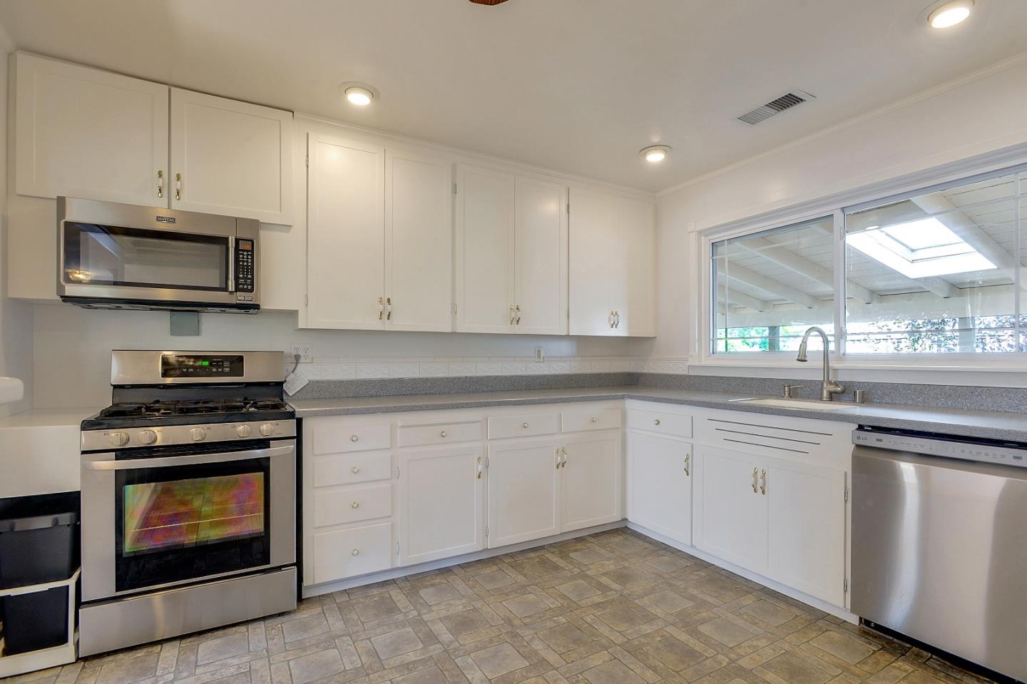 1228 Ruby Street Redwood City, CA 94061 - Photo 8 of 28 a kitchen with granite countertop white cabinets stainless steel appliances and a window