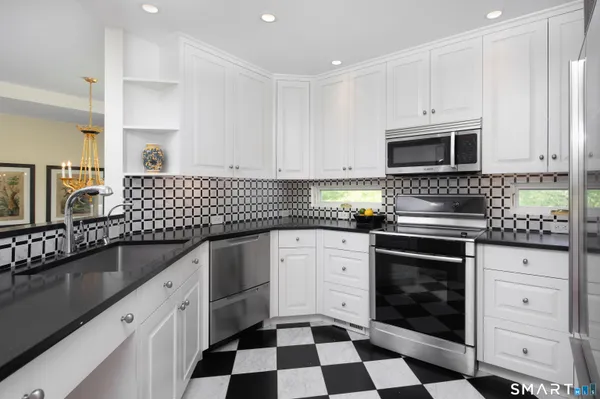 a kitchen with granite countertop cabinets stainless steel appliances and a sink