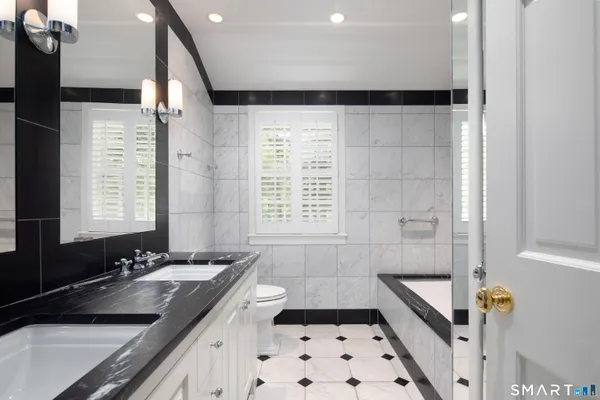 a bathroom with a sink a toilet a mirror and shower