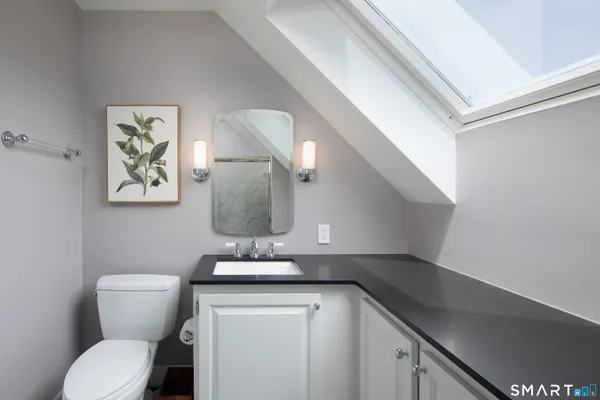 a bathroom with a toilet sink and mirror