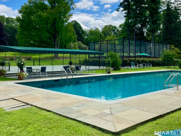 a view of a swimming pool with a patio and a yard