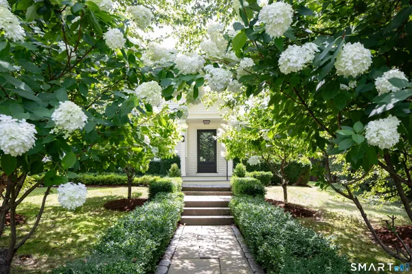 a front view of a house with a garden