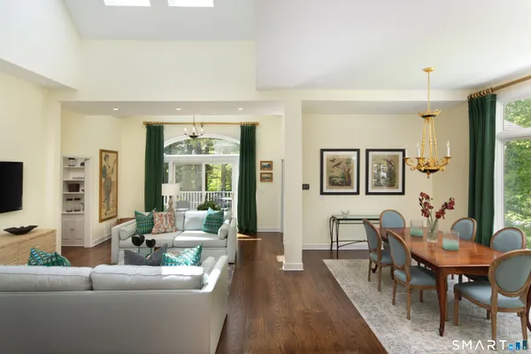 a living room with furniture two window and a flat screen tv