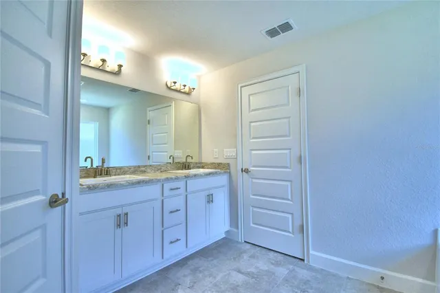 a bathroom with a granite countertop sink and a mirror
