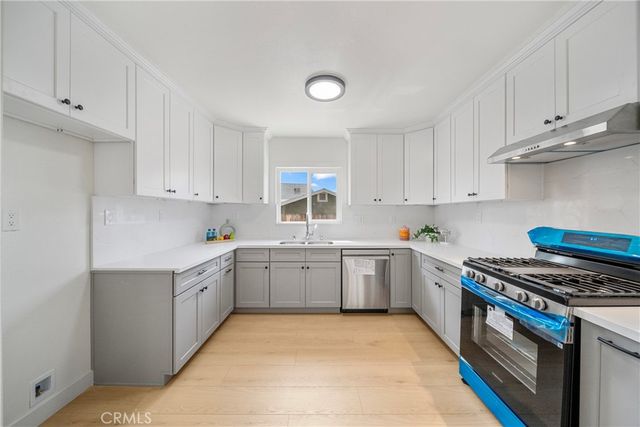 a kitchen with cabinets appliances and a window