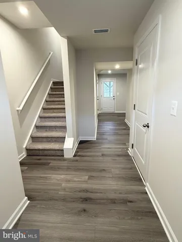 an empty room with wooden floor and stairs