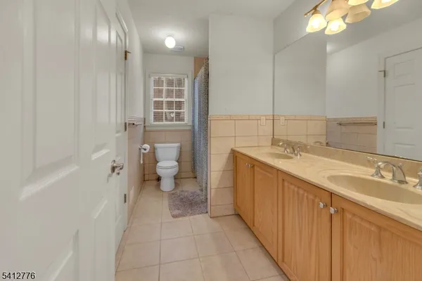 a spacious bathroom with a granite countertop sink a toilet and shower