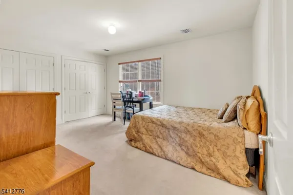 a bedroom with a bed and dresser with cabinet