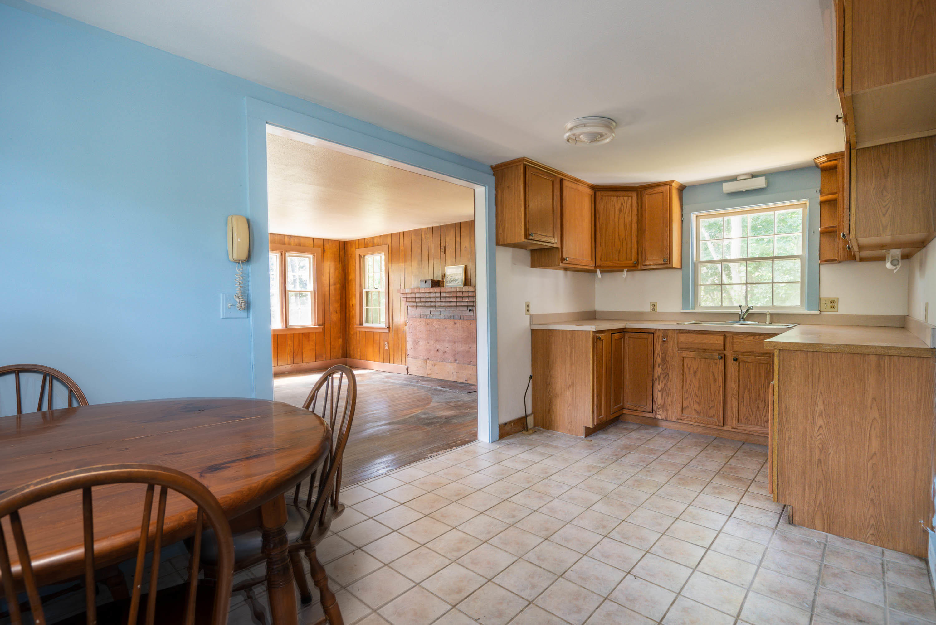66 Pilgrim Spring Road Wellfleet, MA 02667 - Photo 10 of 21 a kitchen with a table chairs refrigerator and cabinets