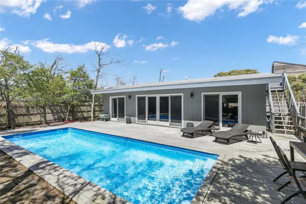 a view of a house with swimming pool and sitting area