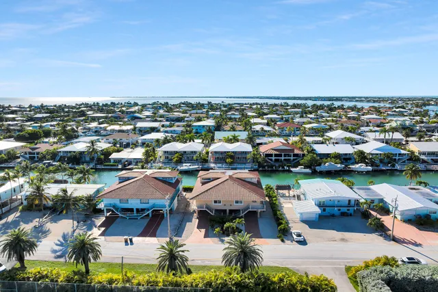 an aerial view of residential houses with outdoor space and street view
