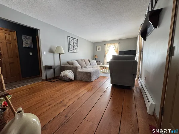 a view of a hallway with wooden floor and a window