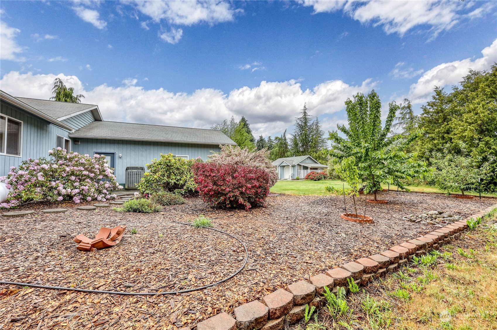 878 North Kendall Road Sequim, WA 98382 - Photo 10 of 30 a view of a garden with a lot of flower plants and wooden fence