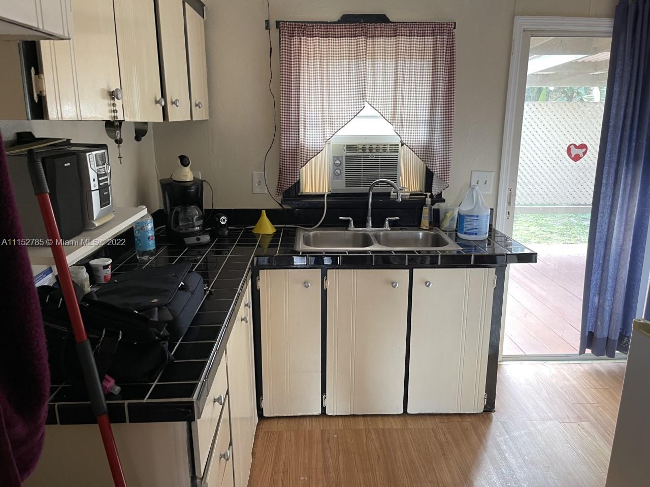 11866 North Branch Road Boca Raton, FL 33428 - Photo 5 of 6 a kitchen with a stove and a wooden floor