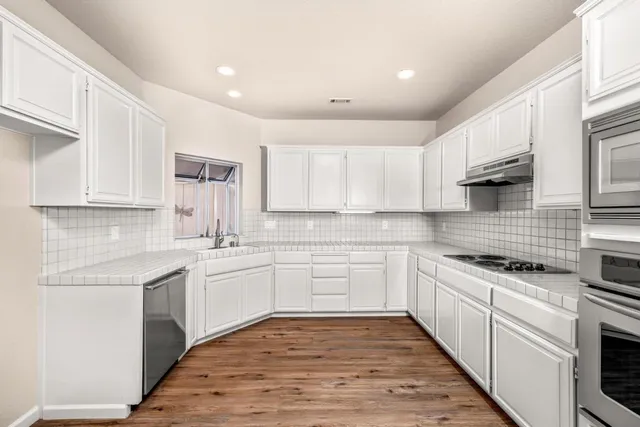 a kitchen with a sink stove and cabinets