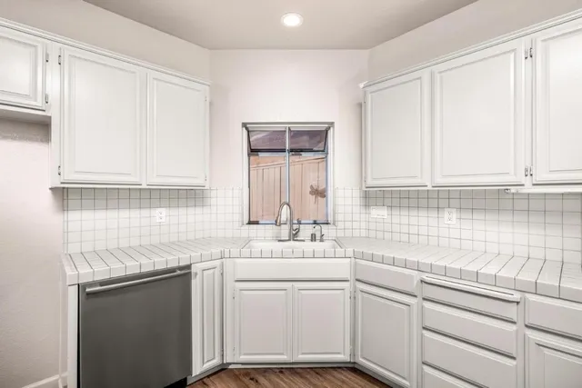 a kitchen with cabinets stainless steel appliances granite countertop white cabinets stove a sink and dishwasher