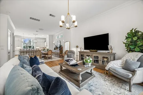 a living room with furniture a flat screen tv and a chandelier