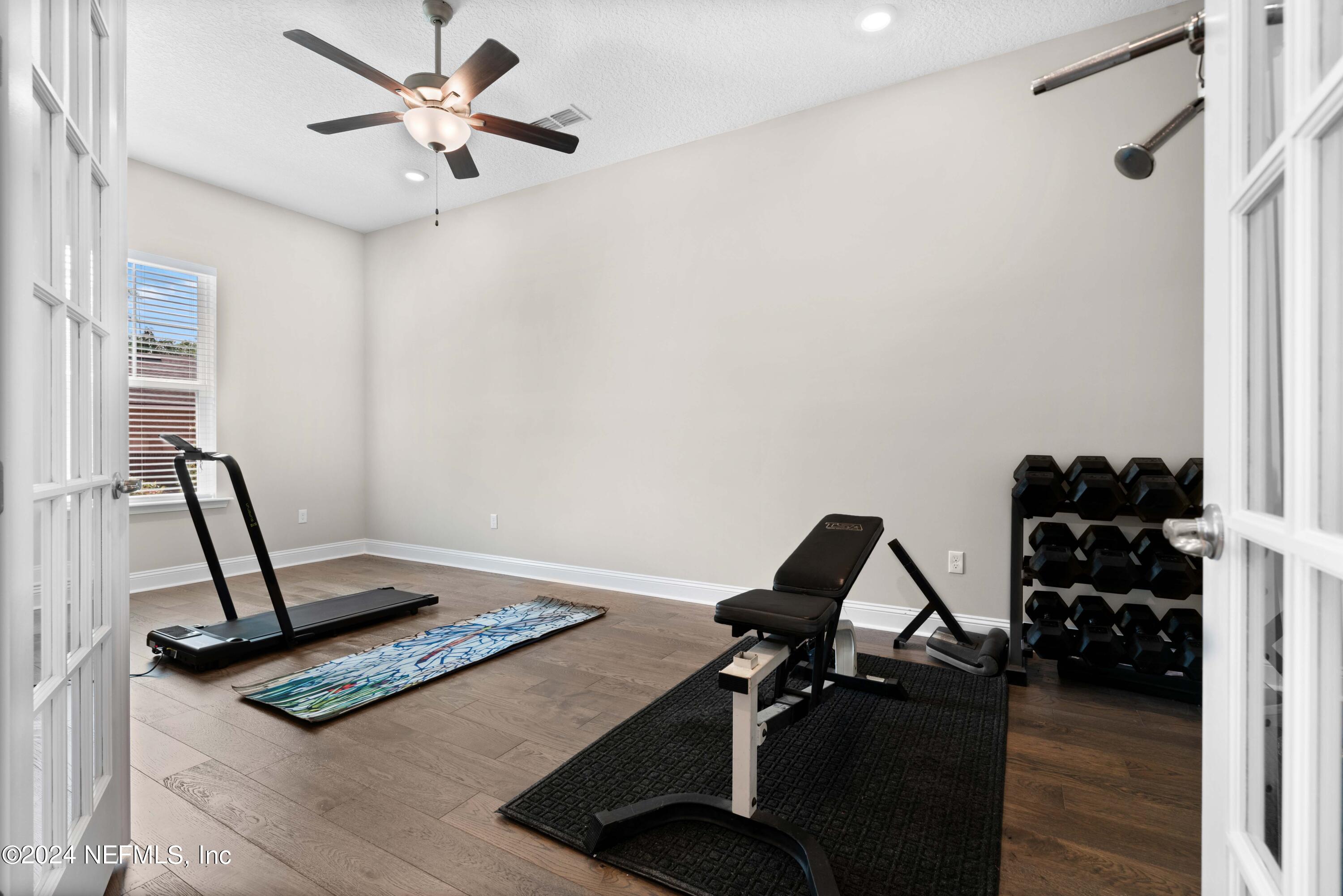 1924 Holmes Circle Fleming Island, FL 32003 - Photo 24 of 58 a room with gym equipment and windows