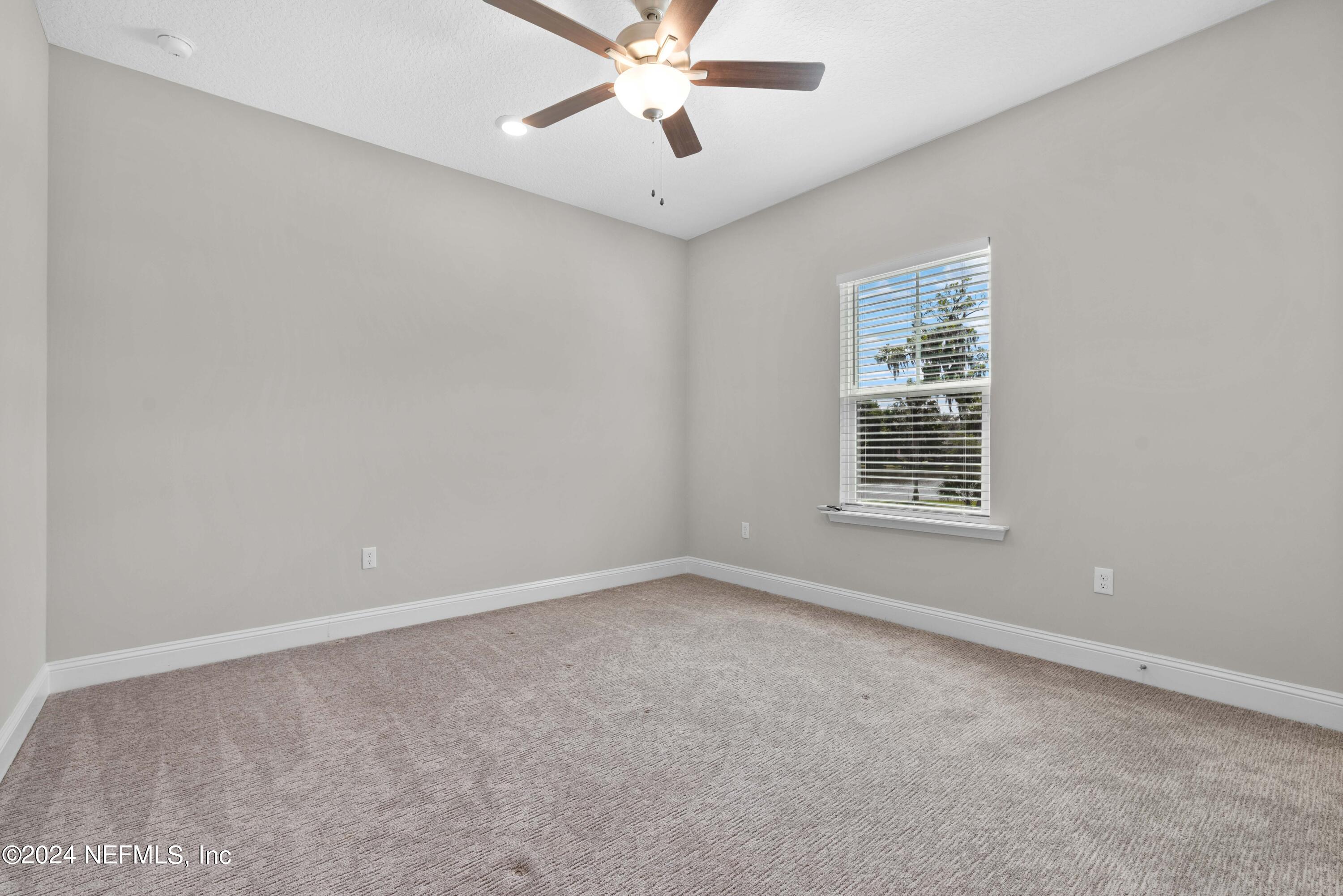 1924 Holmes Circle Fleming Island, FL 32003 - Photo 31 of 58 an empty room with windows and ceiling fan