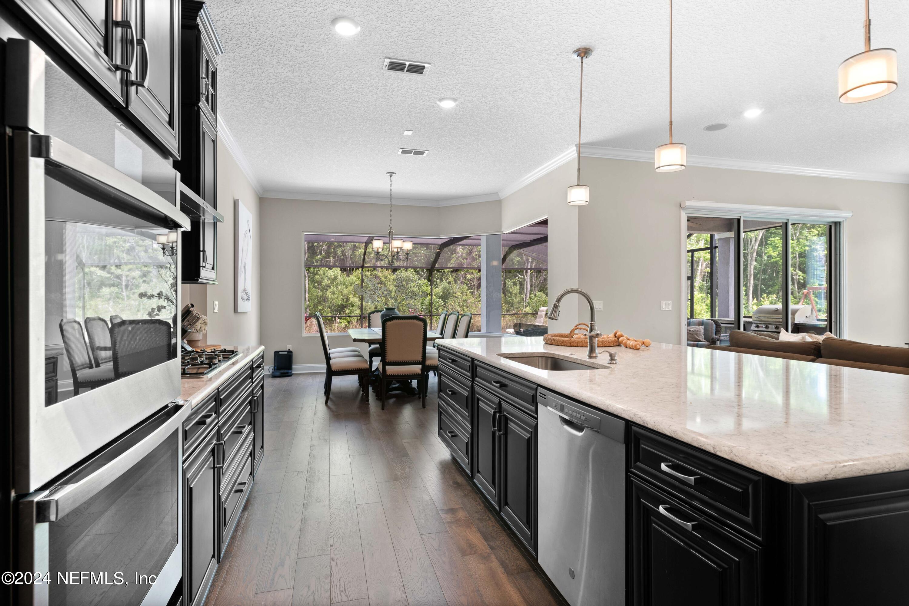 1924 Holmes Circle Fleming Island, FL 32003 - Photo 10 of 58 a kitchen with stainless steel appliances granite countertop a sink a stove and a wooden floors