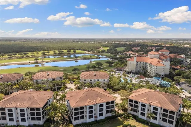 an aerial view of residential houses with outdoor space and ocean view