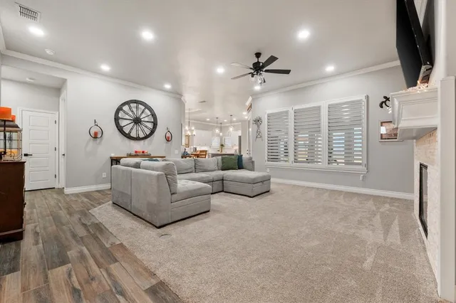 a living room with furniture a flat screen tv and a wall clock