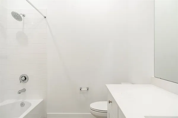 a white toilet sitting next to a white cabinet