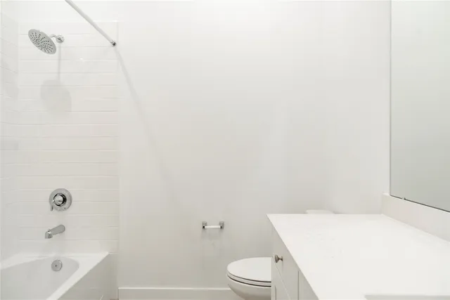 a white toilet sitting next to a white cabinet