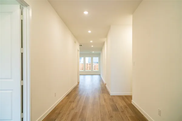 a view of a hallway with wooden floor