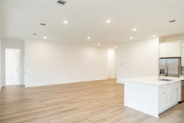 a view of kitchen with stainless steel appliances cabinets and wooden floor