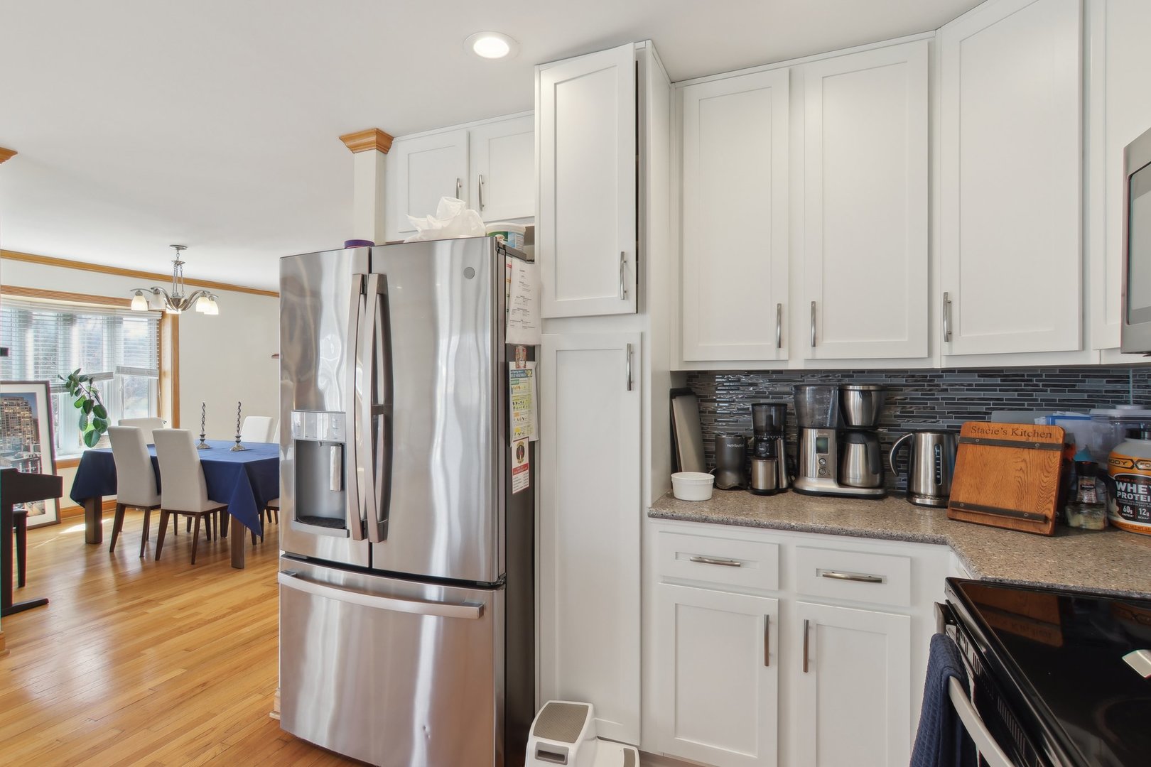 1115 Whitfield Road Northbrook, IL 60062 - Photo 14 of 54 a kitchen with stainless steel appliances granite countertop a refrigerator a stove and white cabinets with wooden floor