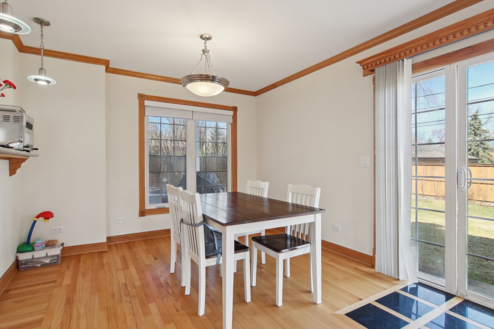 1115 Whitfield Road Northbrook, IL 60062 - Photo 15 of 54 a dining room with wooden floor a chandelier a wooden table and chairs