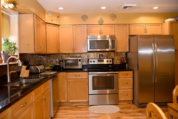 a kitchen with stainless steel appliances a stove a sink and a refrigerator