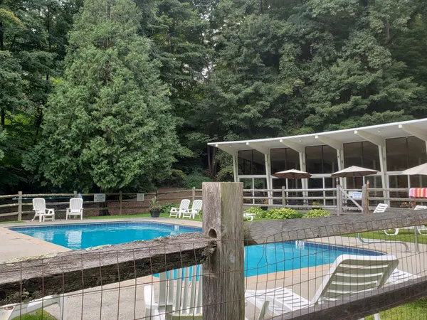 a view of house with swimming pool and sitting area