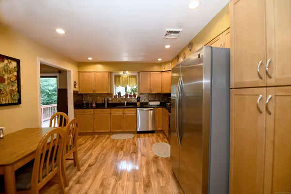 a kitchen with stainless steel appliances a refrigerator and a wooden floor