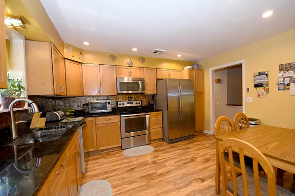a kitchen with stainless steel appliances granite countertop a sink stove and refrigerator