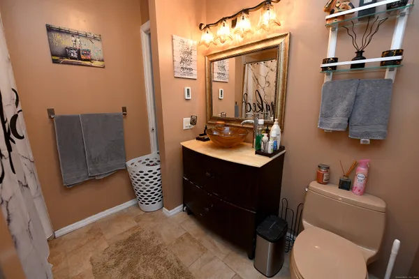 a bathroom with a sink vanity mirror and toilet