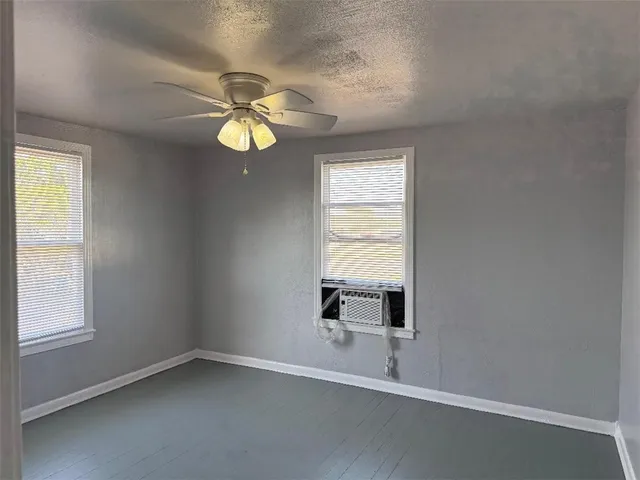 a view of an empty room and chandelier fan