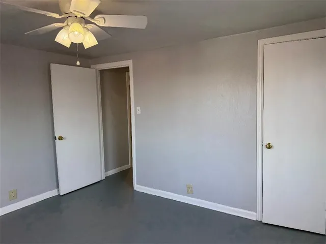 an empty room with a chandelier fan and a chandelier fan