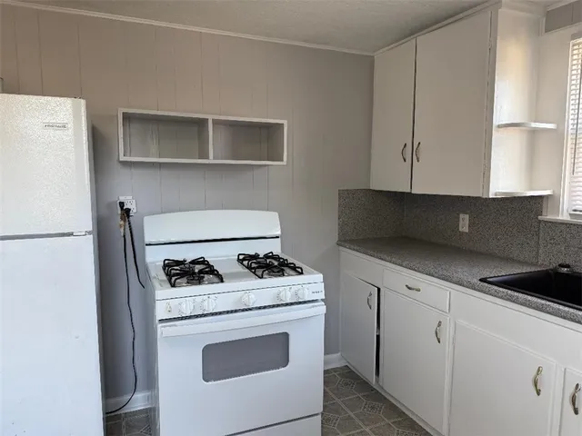 a kitchen with granite countertop white cabinets and black appliances