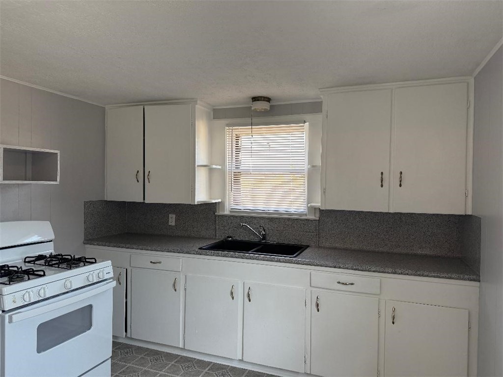 810 8th Avenue Portland, TX 78374 - Photo 8 of 16 a kitchen with granite countertop white cabinets and black appliances