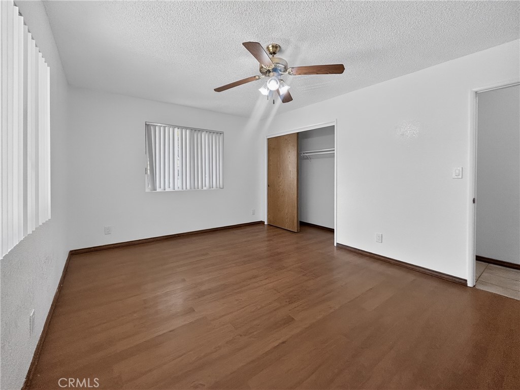 7451 Diamond Street Riverside, CA 92504 - Photo 21 of 31 an empty room with wooden floor ceiling fan and windows