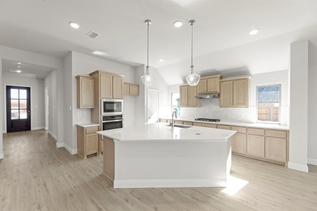 395 Misty Meadow Lane Lavon, TX 75166 - Photo 2 of 24 a large kitchen with stainless steel appliances kitchen island granite countertop a large center island attached withe living room