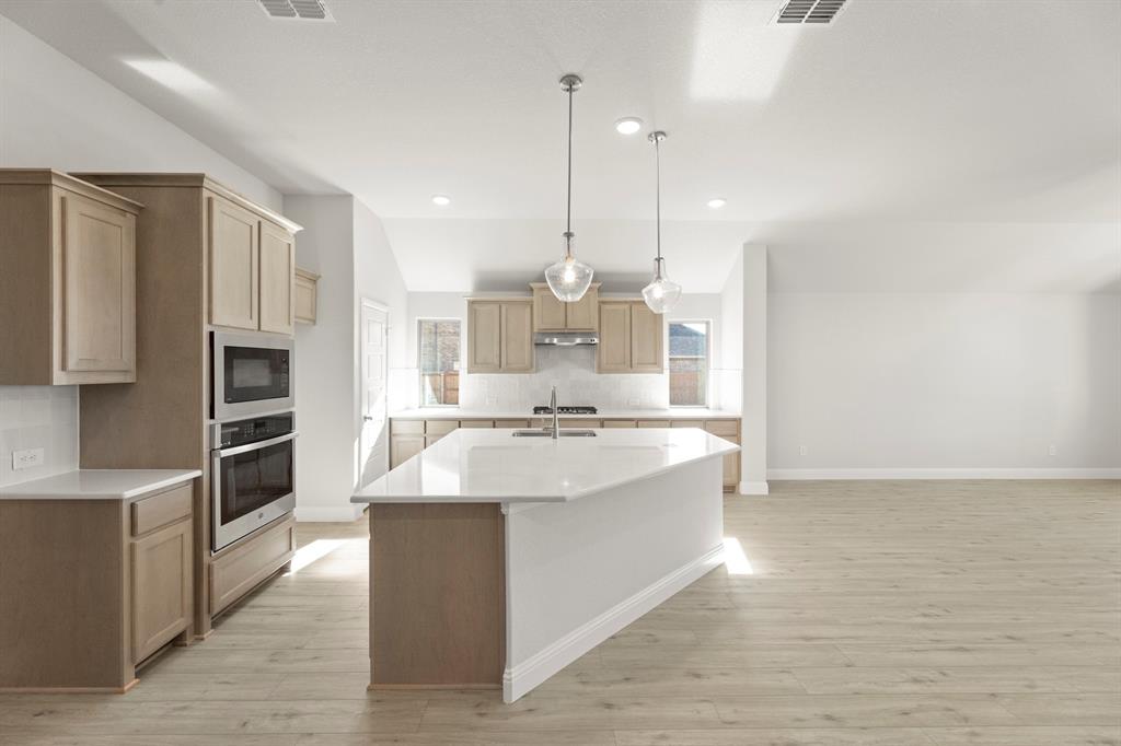 395 Misty Meadow Lane Lavon, TX 75166 - Photo 3 of 24 a large kitchen with kitchen island a sink stainless steel appliances and cabinets